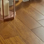 Close-up of honey oak wood floor with candle lantern.