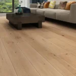 Modern living room with light oak floors and dark table.