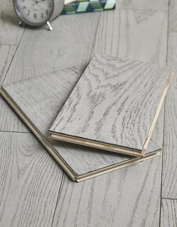 Two light gray wood flooring samples stacked
